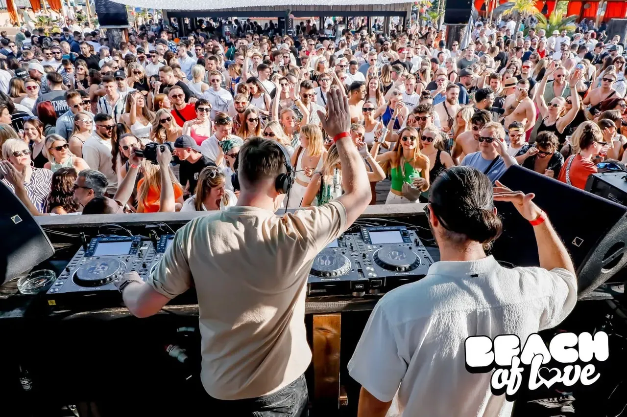 DJs und Publikum mit erhobenen Händen bei der Beach of Love